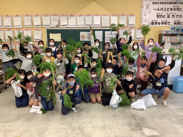 収穫したにんじんをもって記念撮影