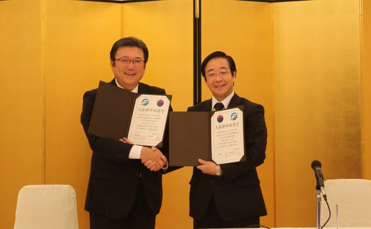 提携書に署名を行い、握手を交わす